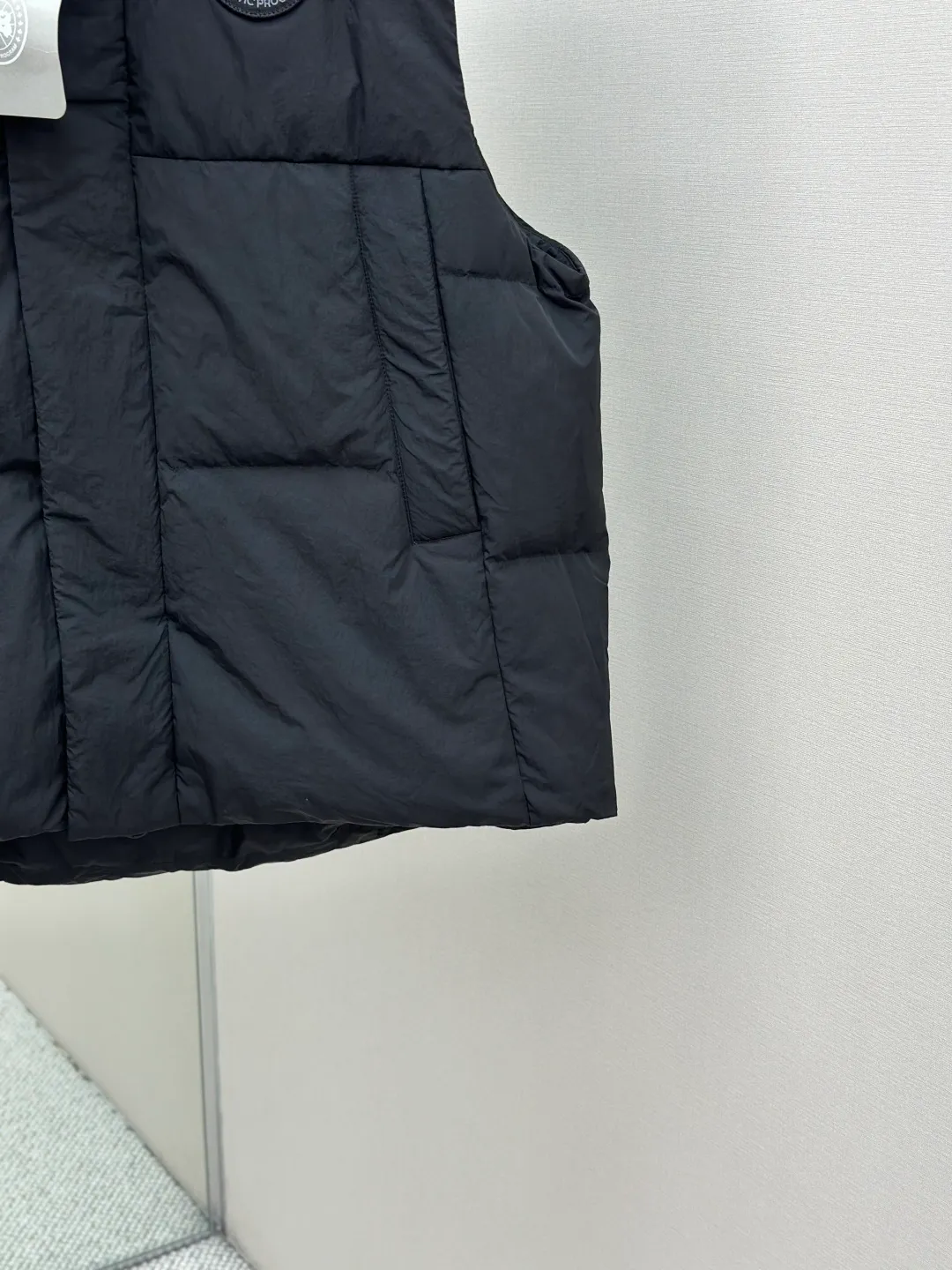 P760 Canada Goose logo hooded down vest Fabric selection: The use of high-quality protective nylon fabric not only enhances the wear resistance of the surface, but also takes into account wind resistance, ensuring excellent performance in various harsh weather conditions.  90 national standard high-quality white duck down: selected high-loft down, weighing 170g, light and warm, with excellent temperature locking performance and good resilience.  Three-dimensional quilting process: Precision thread reinforcement to prevent velvet drilling and ensure that the fluffy and resilient elasticity lasts as new.  Details: Use polyester as the base for woven webbing, and use high-precision computer embroidery to decorate the brand letters on the webbing. The edges of the pattern are clear, the stitches are fine and even, and multiple layers of embroidery threads are stacked to enhance the three-dimensional effect. Accessories: Customized logo Customized zipper pendant Customized hem elastic buckle Customized snap button SIZE: S M L XL